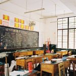a classroom filled with desks and a chalkboard