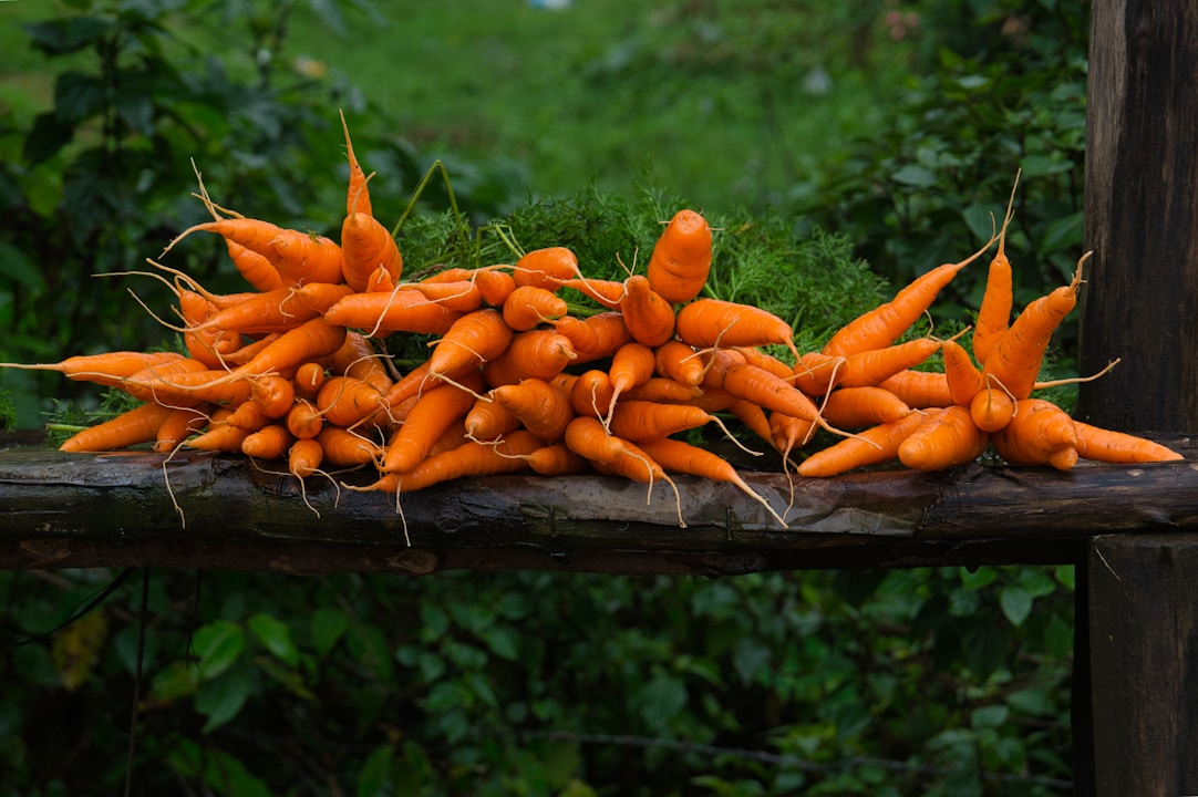 A pile of carrots sitting on top of a wooden table