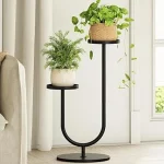 The image shows a sleek, modern plant stand showcasing indoor plants, part of a review on minimalist stands.